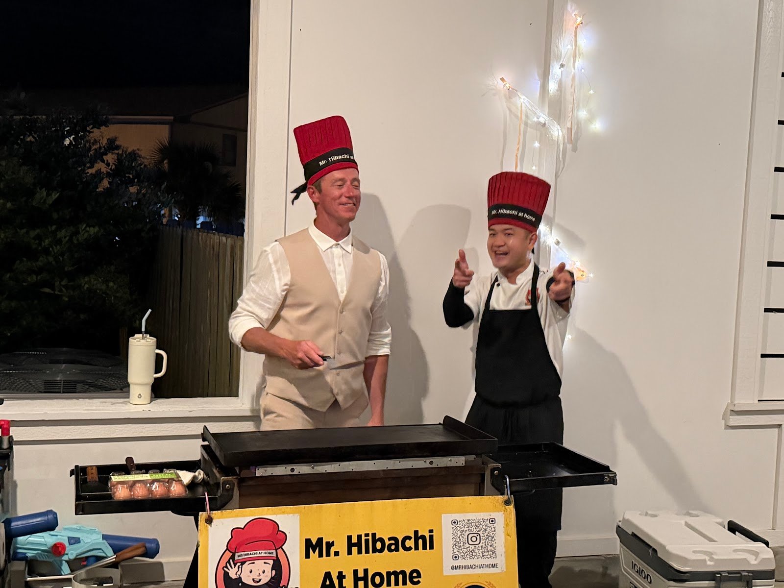Guest wearing a chef hat alongside the private hibachi chef during a graduation celebration on 30A
